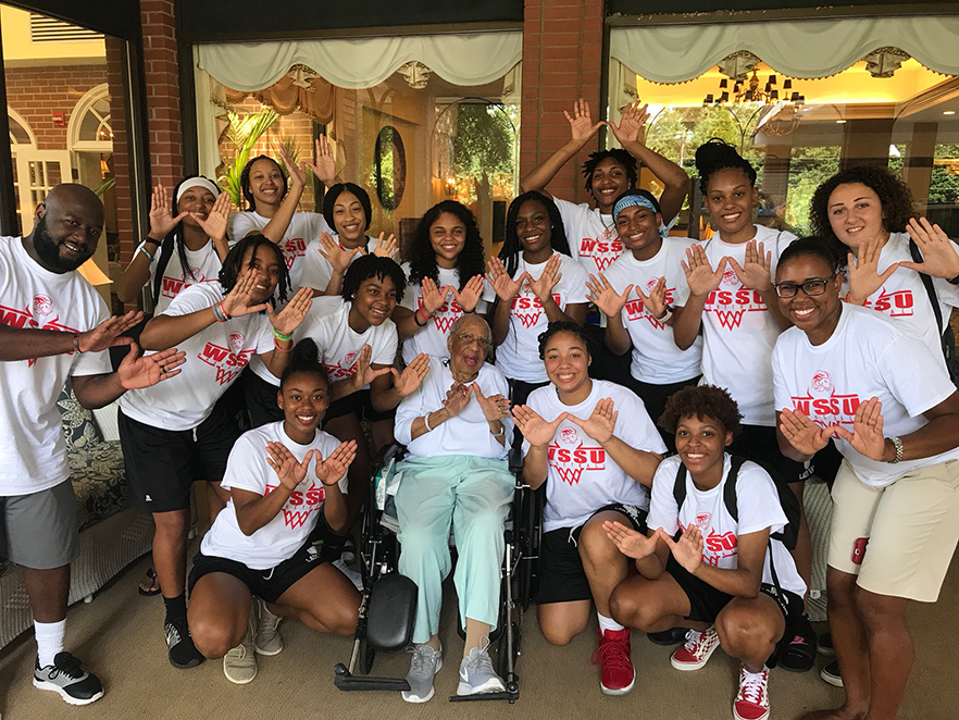 Women's basketball team with 103 year old alumna