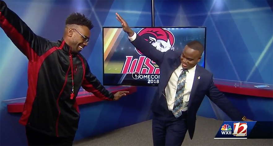 WSSU drum major and WXII anchor stand in studio with large screen