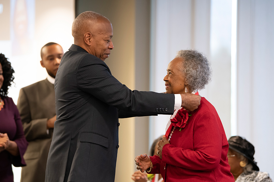 Chancellor Robinson places medallion around neck of honoree