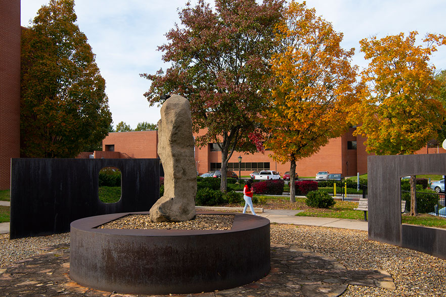 Outdoor sculpture with fall colors in background