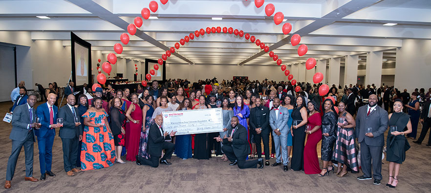 inductees stand with a big check
