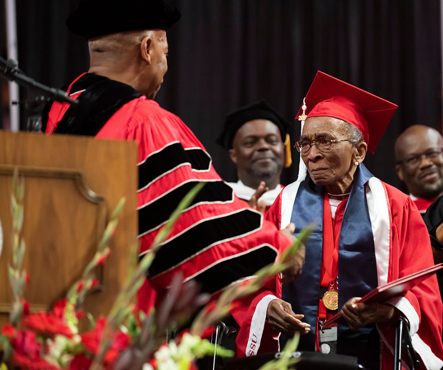 Elizabeth Johnson receives her degree from Chancellor Robinson