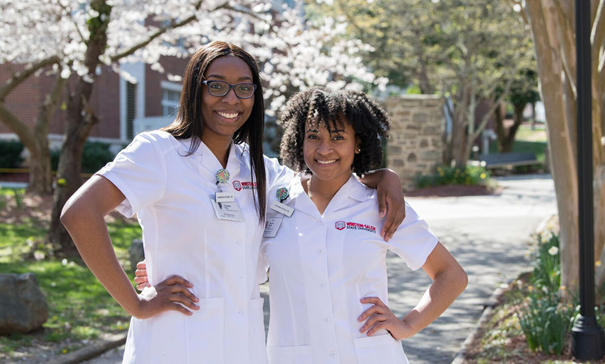 Sisters in uniform near the archways on campus