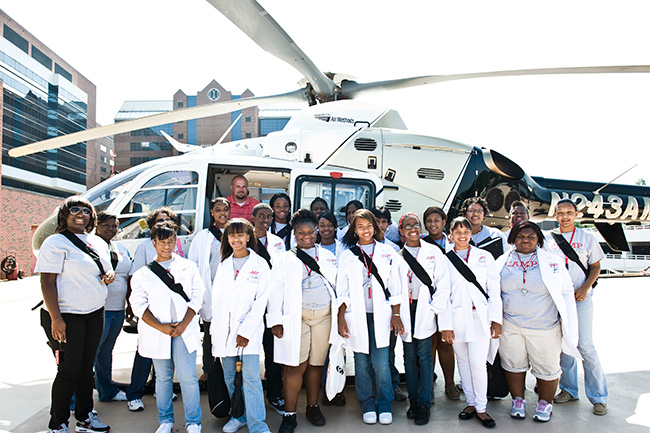 Camp youth standing in front of YEH Air Care helicopter.
