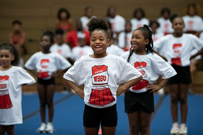 Camp youth standing in formation during Cheer Camp, wearing Future WSSU Cheerleader shirts.
