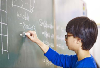 a boy writing on a chalkboard