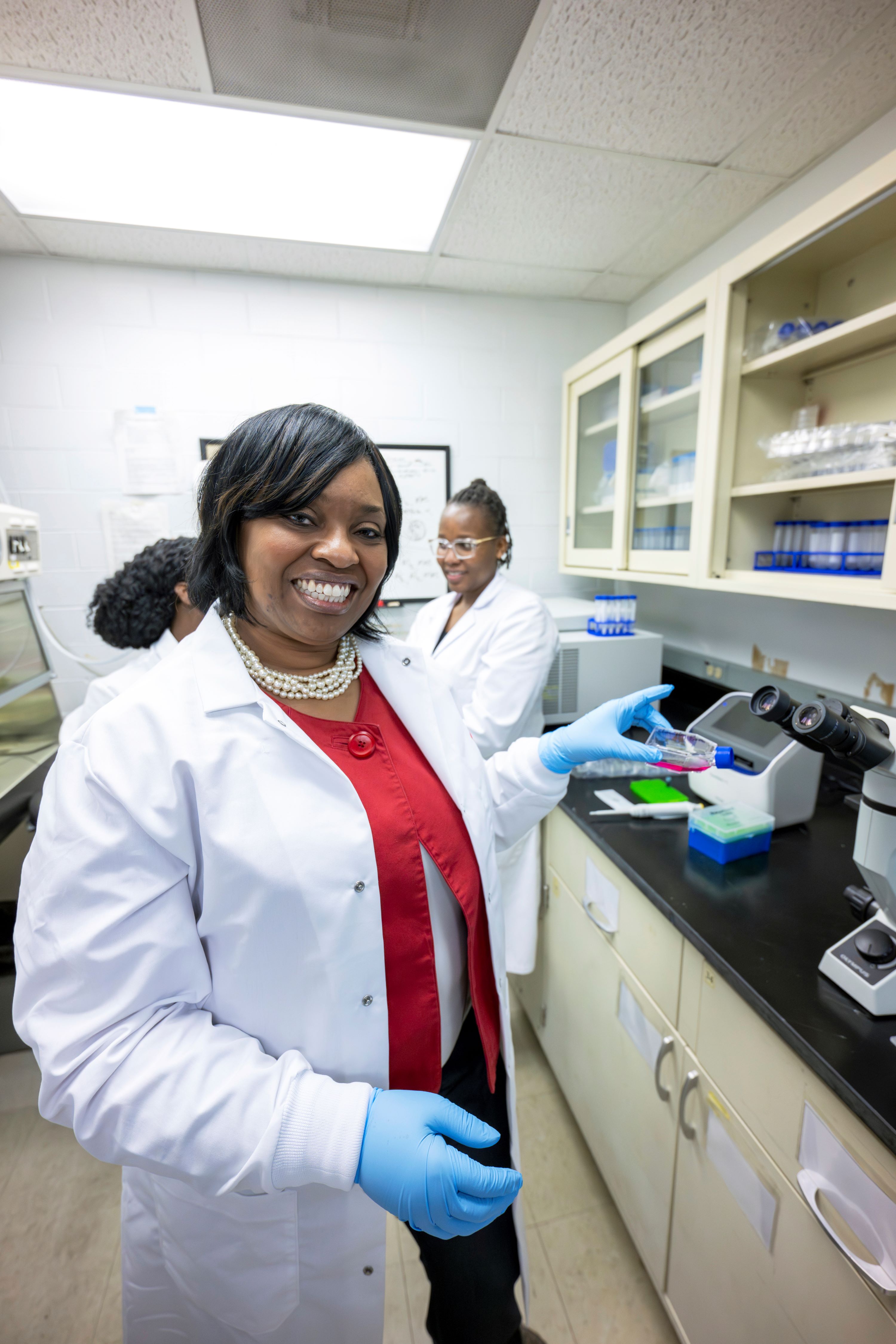 Chancellor Brown holds cell culture